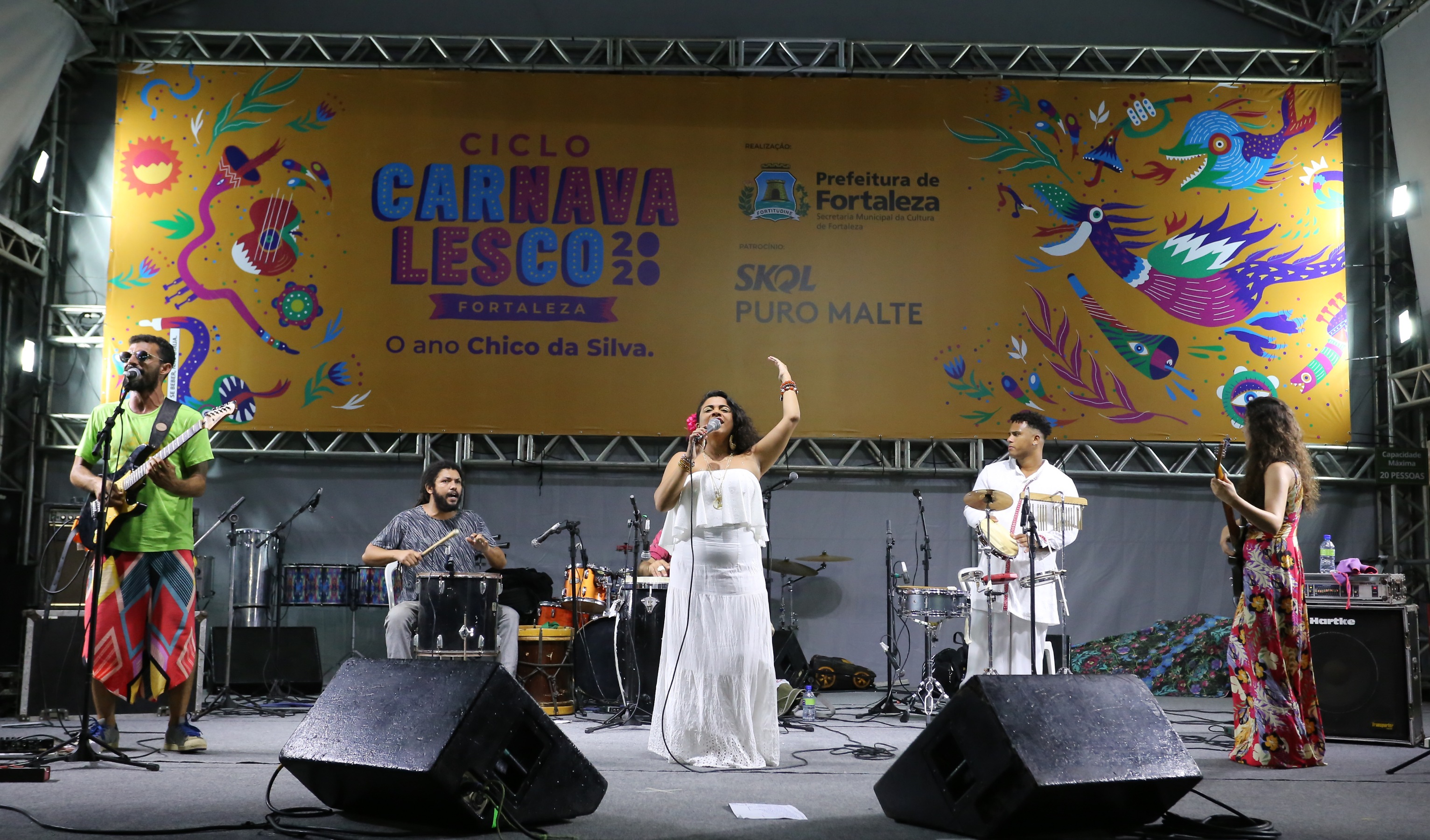 mulher cantando com banda em cima de palco